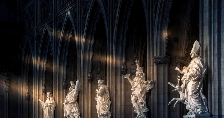 Dieses Bild zeigt Statuen von diversen Heiligen in einer barocken Kirche. 
